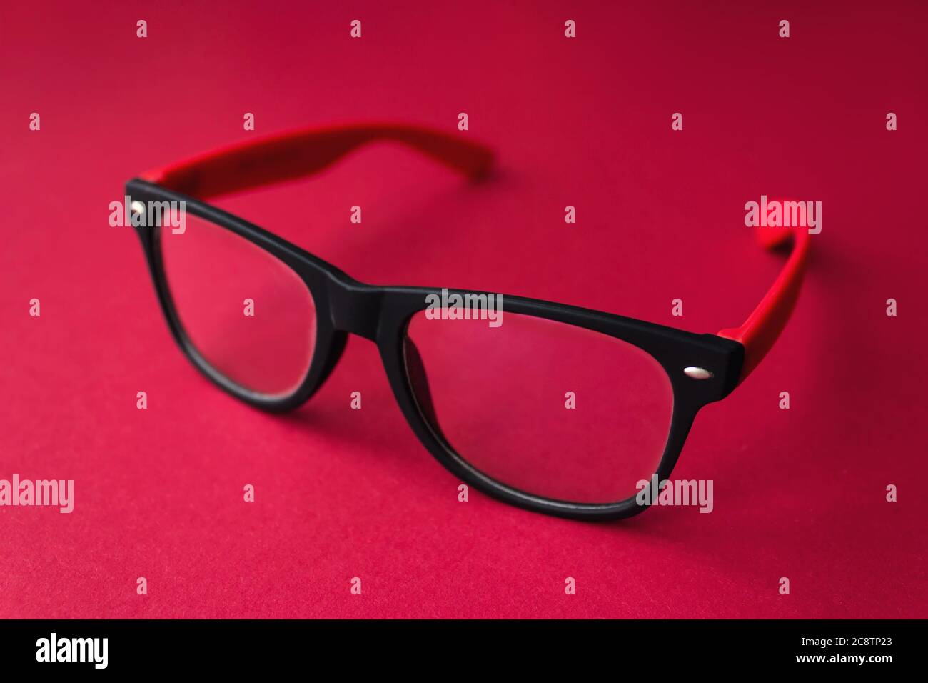 Moderne modische graduierte Gläser auf rotem Hintergrund, Gläser Stockfoto