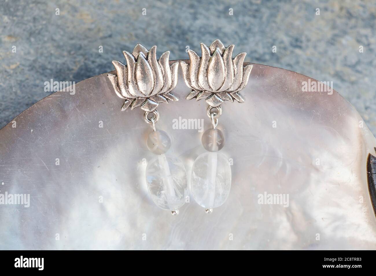 Lotus Form Kristall Quarz Achat Perle weibliche Ohrringe auf neutralem Hintergrund Stockfoto