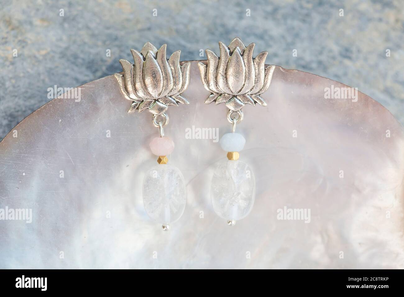 Lotus Form Kristall Quarz takettiert Morganit Perle weibliche Ohrringe auf neutralem Hintergrund Stockfoto