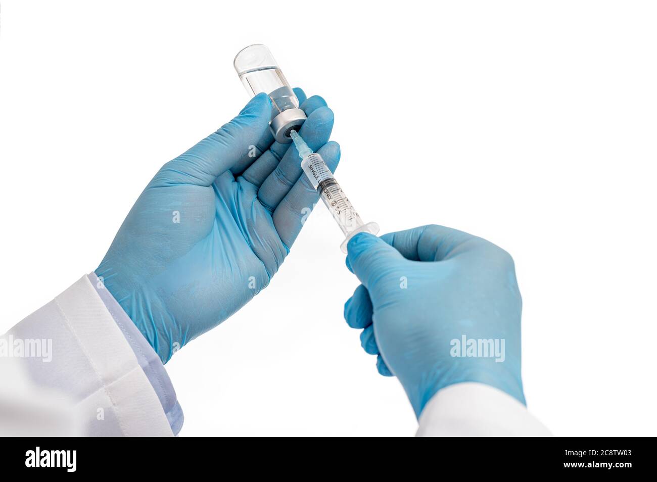 Die Hand des Wissenschaftlers trägt blaue Handschuhe vor weißem Hintergrund und hält den Covid-19-Impfstoff. Stockfoto
