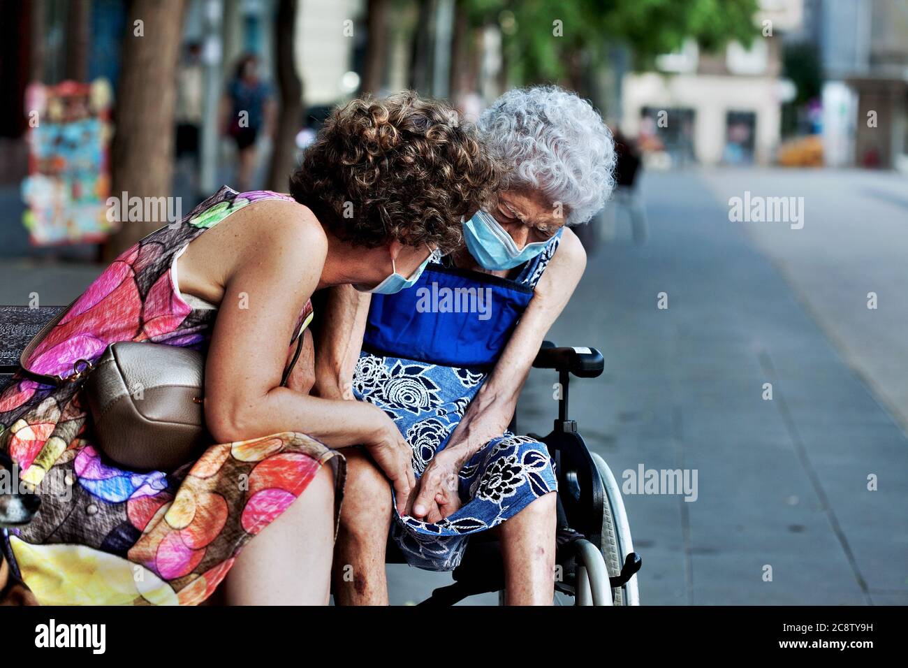 Eine Frau tröstet ihre gebrechliche, ältere Mutter, Barcelona, Spanien. Stockfoto