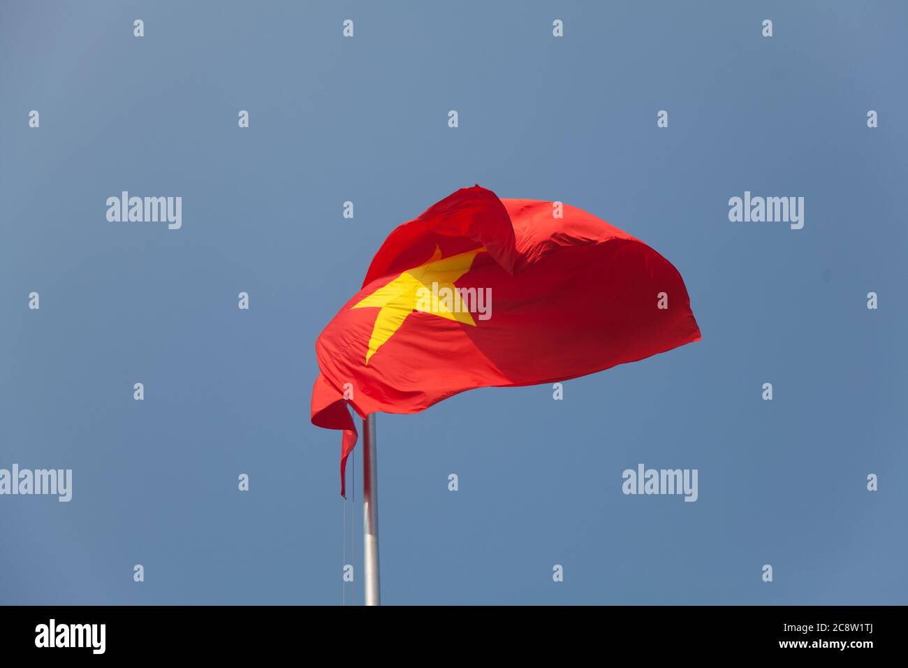 Vietnam Nationalflagge weht im Wind gegen einen perfekten blauen Himmel Stockfoto