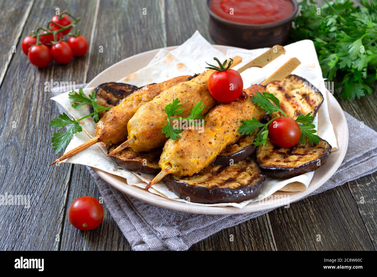 Lula Kebab mit gegrillter Aubergine auf Pita-Brot. Diätetische Hühnerkebabs auf einem Spieß mit Gemüse. Stockfoto