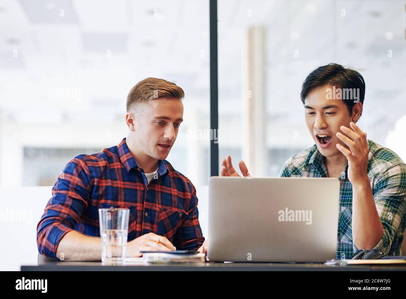 Junge multiethnische Geschäftsleute beobachten Online-Webinar auf Laptop, um neue Fähigkeiten für die Geschäftsentwicklung zu lernen Stockfoto