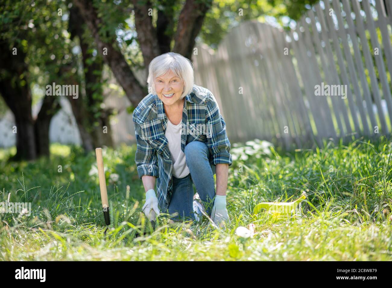 Lächelnde ältere Frau, die Obst und Gemüse pflanzt Stockfoto