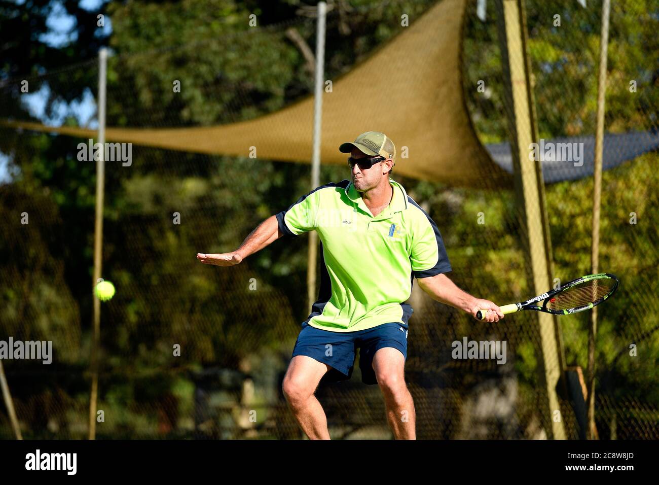 Ein Tennisspieler bereitet sich darauf vor, den Ball während eines Tennisspiels in Victoria Australia zu schlagen Stockfoto