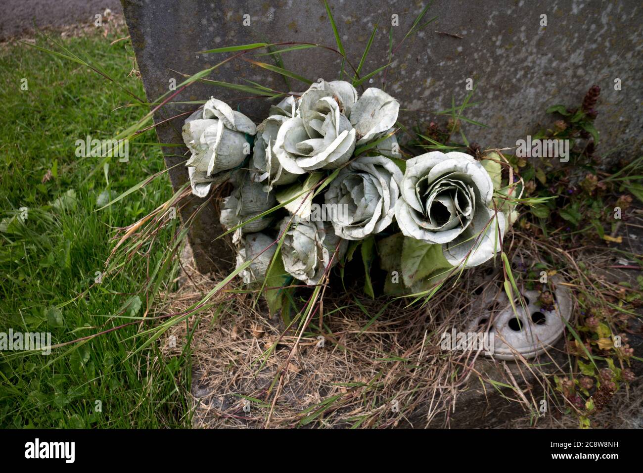 Künstliche Blumen auf einem Grab, Großbritannien Stockfoto