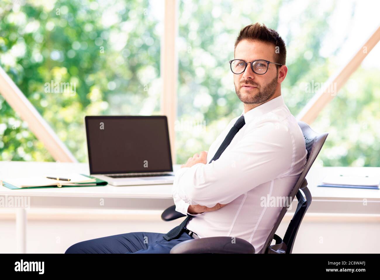 Geschäftsmann mit Hemd und Krawatte, der am Schreibtisch sitzt und arbeitet. Stockfoto