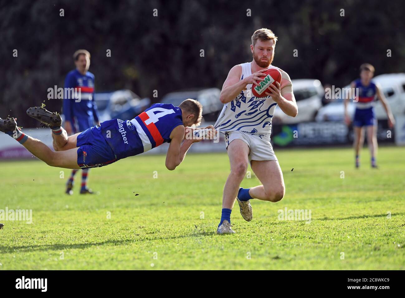 Ein Tarrawingee-Fußballspieler hängt sich während eines Fußballspiels in North East Victoria, Australien, von Hell aus an das Hemd seines Gegners Stockfoto