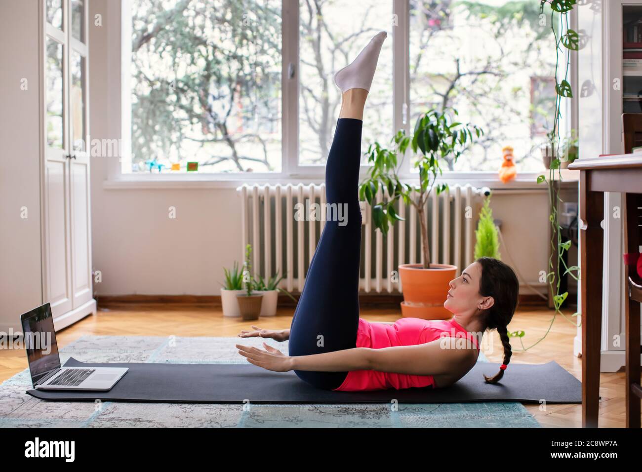 Schöne junge Frau Ausübung Pilates, Yoga, Fitness zu Hause Blick auf den Laptop Stockfoto