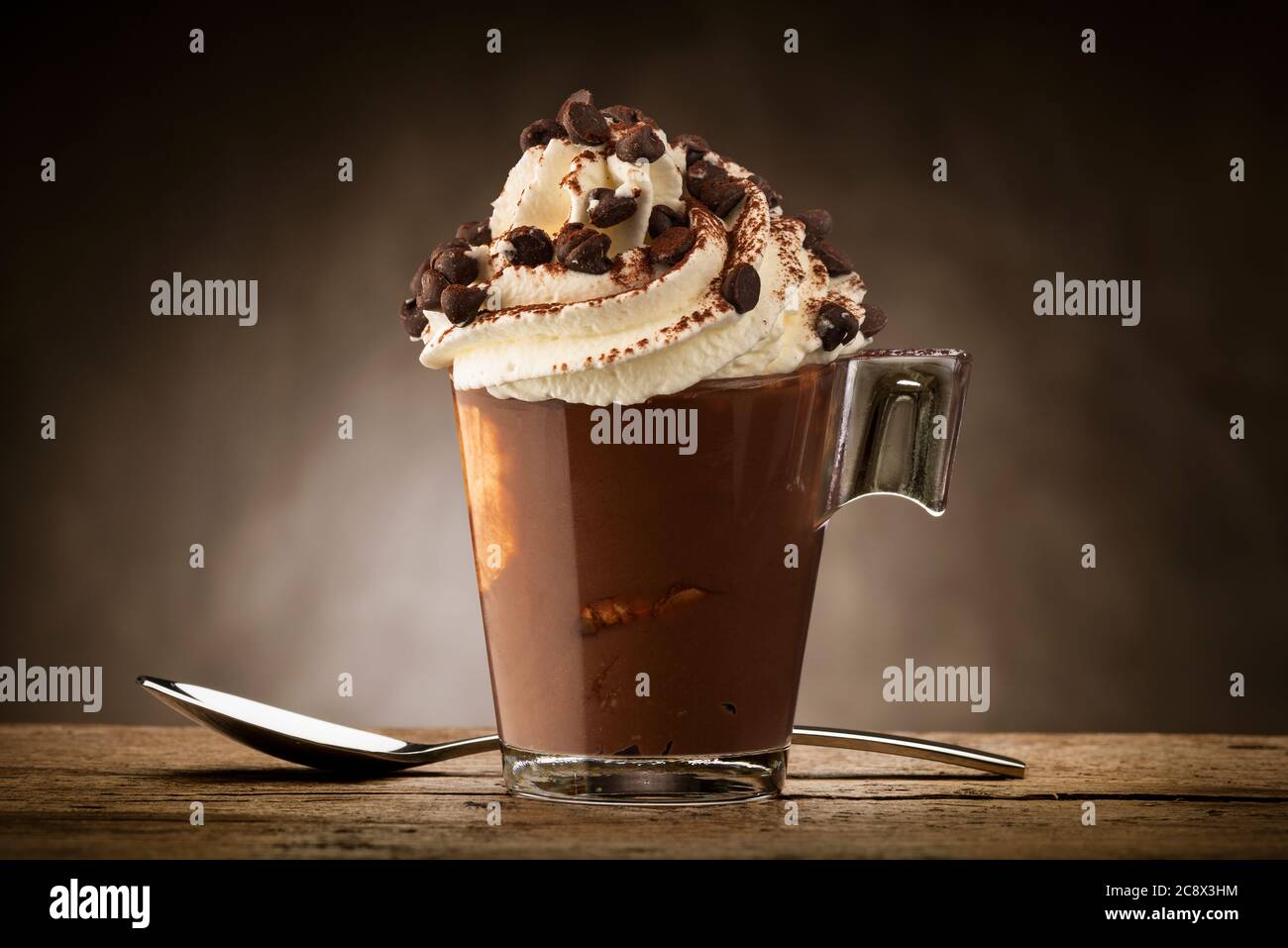 Tasse Kaffee mit Schlagsahne, Kakaopulver und Schokoladenstückchen. Stockfoto
