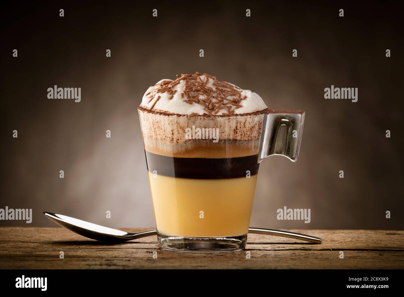 Tasse Kaffee mit Milchschaum, weißer Schokolade und Schokoladenstückchen. Stockfoto