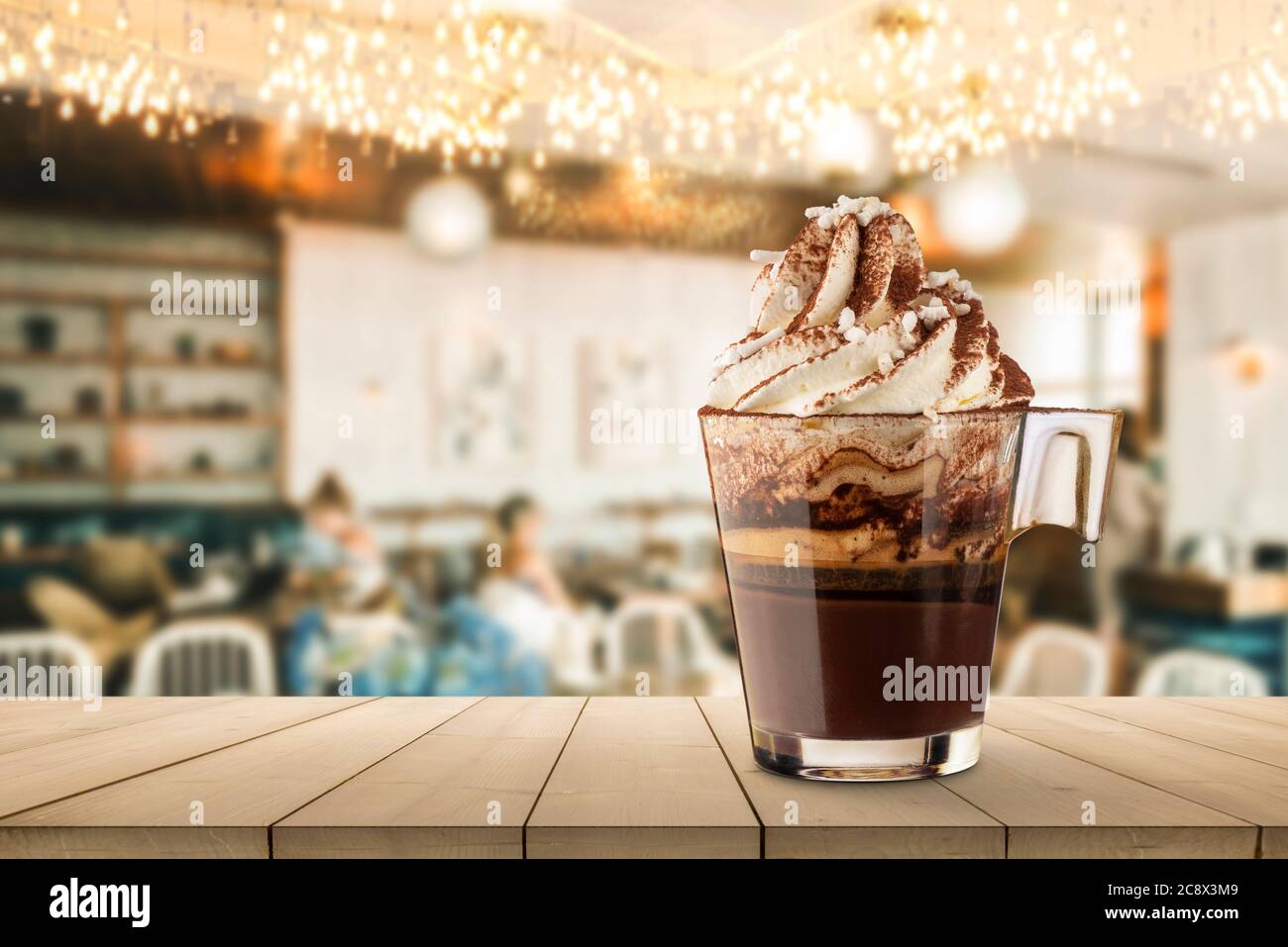 Tasse Kaffee mit Schlagsahne auf Holztisch in das Café. Stockfoto