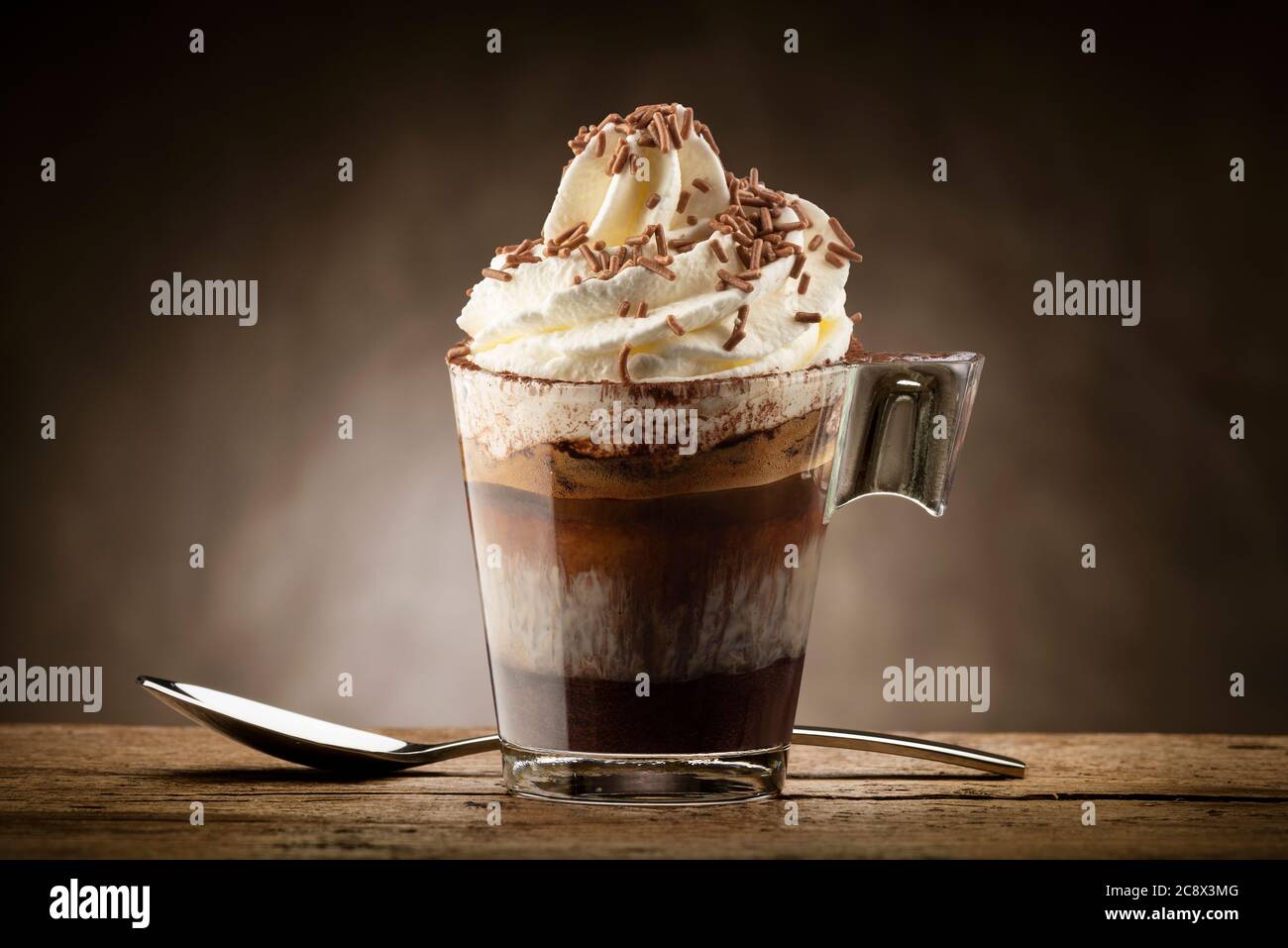 Tasse Kaffee mit Schlagsahne, Milchschaum und Schokoladenstückchen. Stockfoto