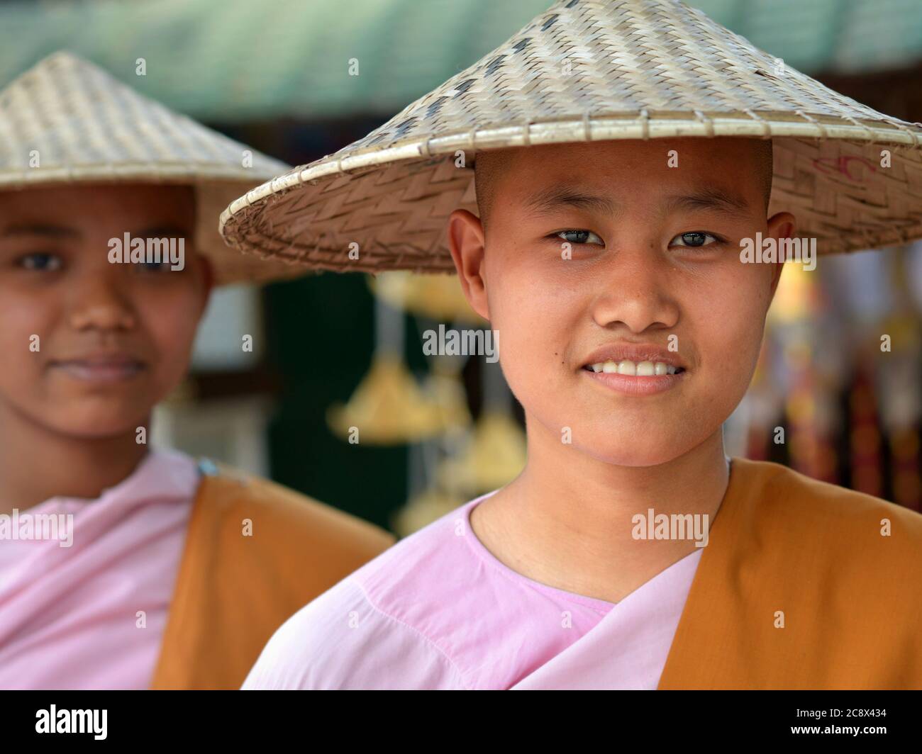 Zwei junge burmesische buddhistische Nonnen mit asiatischen konischen Hüten. Stockfoto