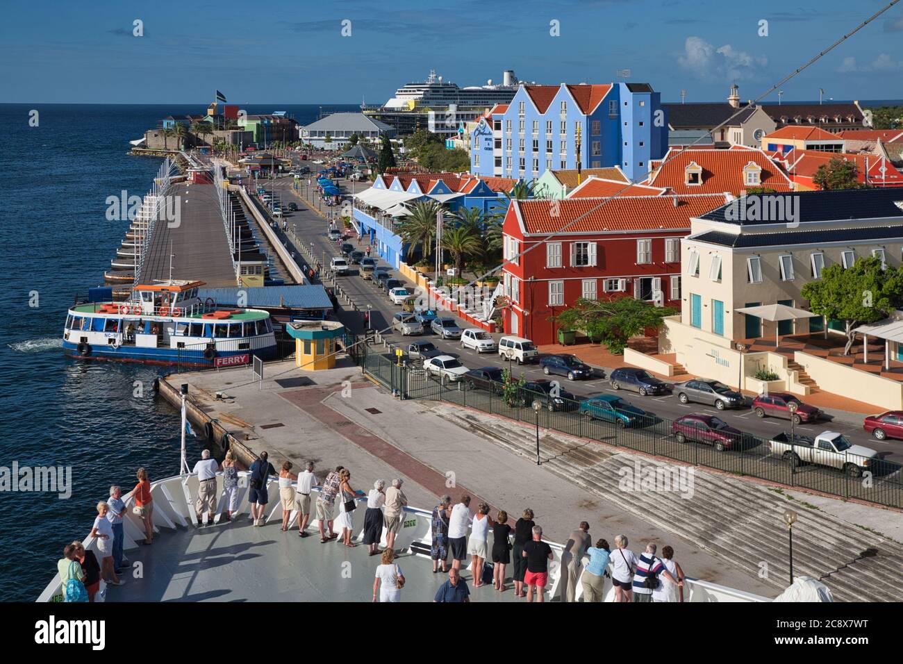 Passagiere auf den Bögen eines Kreuzfahrtschiffes sehen die bunte Architektur und Gebäude in Willemstad, Curacao, der Karibik Stockfoto