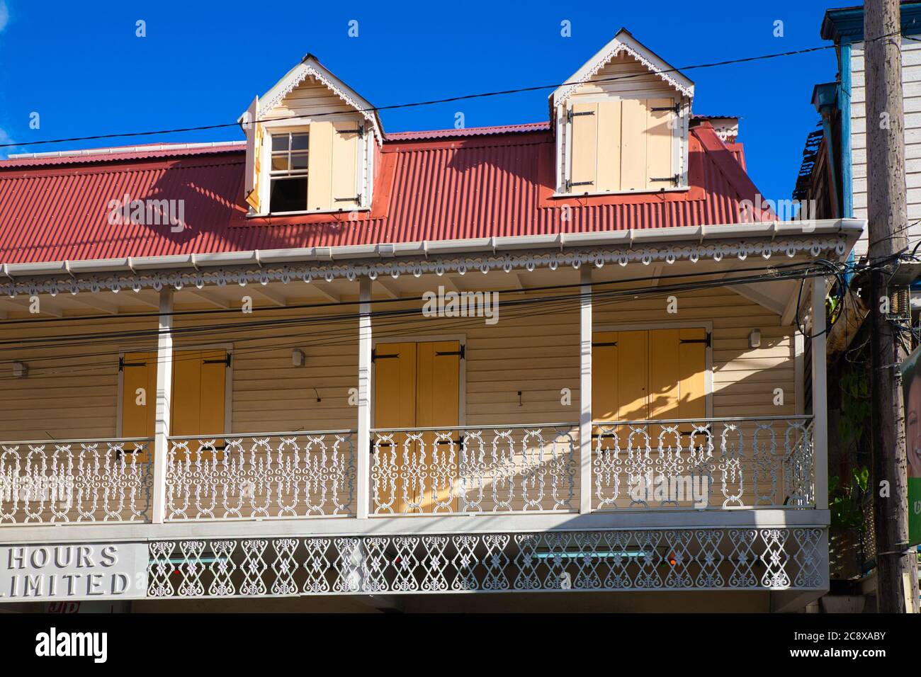 Schöne Veranda auf einem Haus mit weißen dekorativen Geländer und rotem Dach in Roseau, Dominica Insel, der Karibik Stockfoto