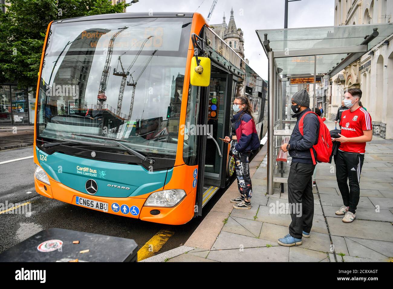 Passagiere stehen in Cardiff an Bord eines Busses, da Gesichtsbedeckungen in den öffentlichen Verkehrsmitteln in Wales obligatorisch werden, um die Ausbreitung des Coronavirus zu verhindern. Stockfoto