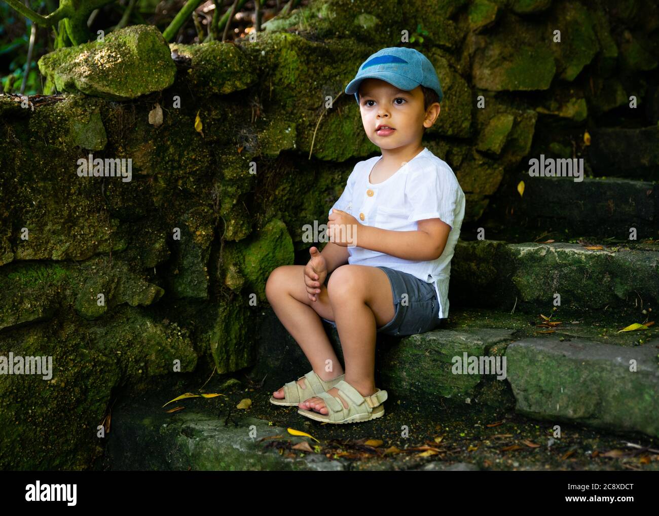Kleiner Junge sitzt auf der Treppe Stockfoto