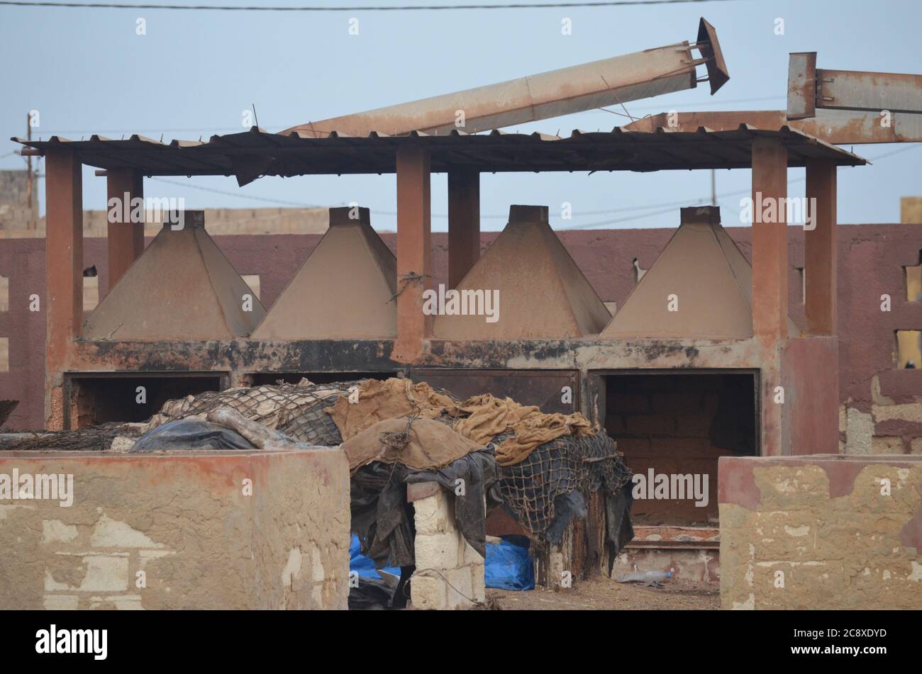 Verlassene Fischöfen mit umgestürzten Kaminen in einer traditionellen Fischverarbeitungsanlage, Joal, Senegal Stockfoto