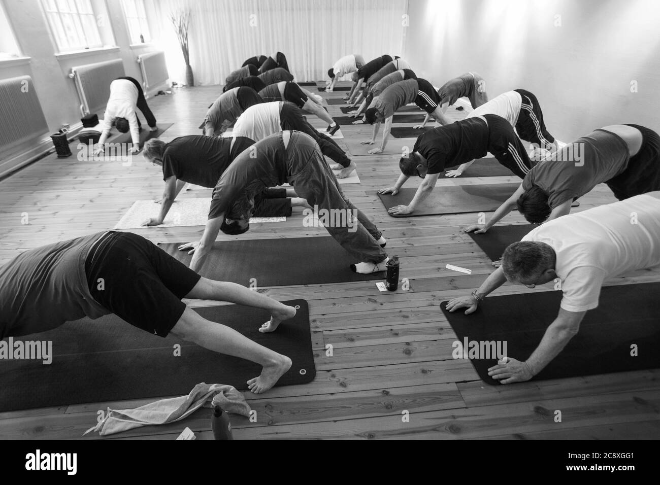 Yoga für steife Männer. Yoga ist eine Gruppe von physischen, mentalen und spirituellen Praktiken oder Disziplinen, die ihren Ursprung im alten Indien haben. Yoga ist eine der sechs Āstika (orthodoxen) Schulen der hinduistischen philosophischen Traditionen. Foto Jeppe Gustafsson Stockfoto
