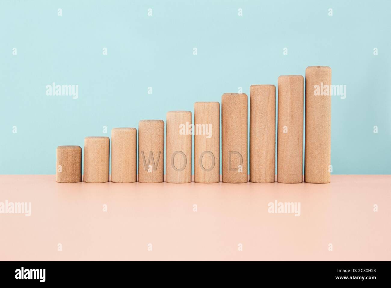 Spielzeug Holzblöcke mit HOLZ Wort als zunehmende Graph bar, Diagramm auf Holztisch über blauem Hintergrund mit Kopierraum Stockfoto