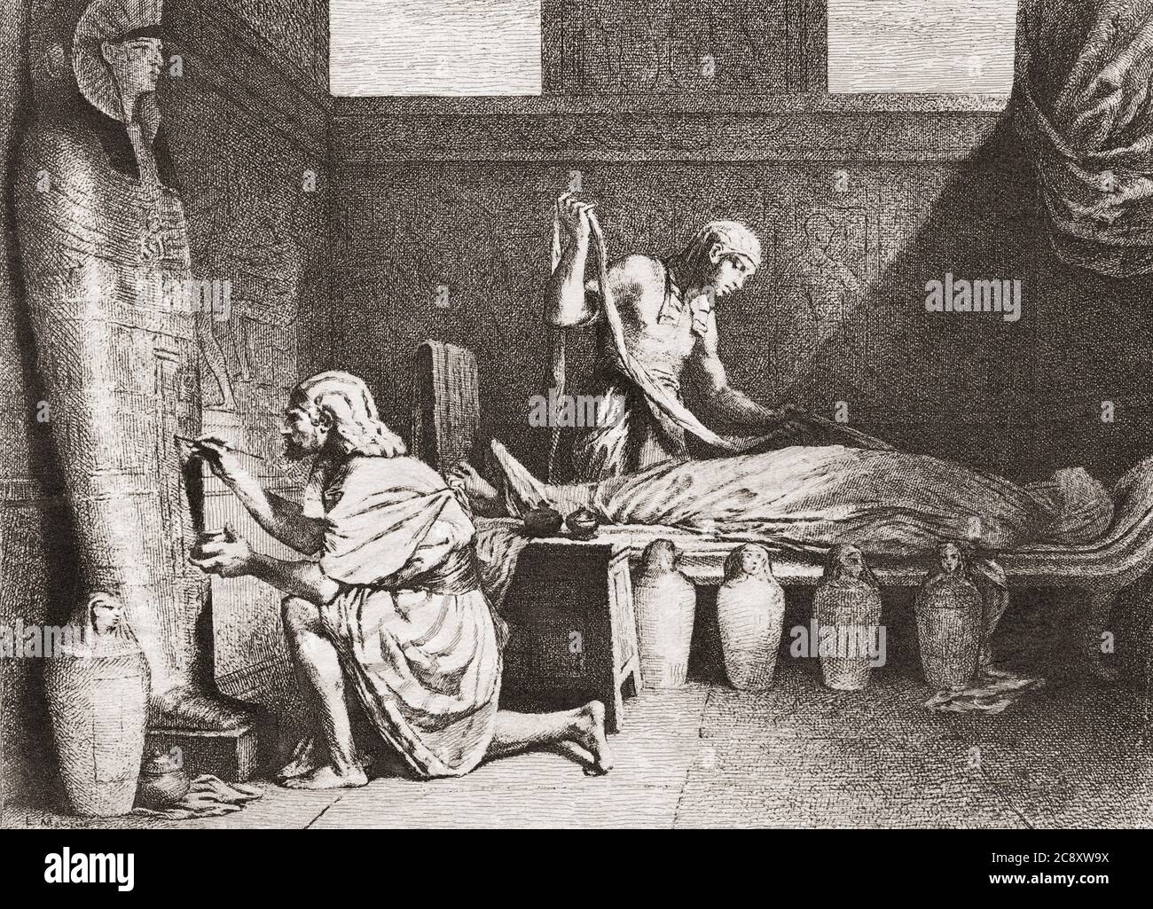 Altägyptische Grabarbeiter bereiten einen Körper für die Mumifizierung vor. Der Arbeiter auf der rechten Seite, der Einbalsammer, beginnt, den künstlich dehydrierten Körper in Leinen zu wickeln und der Mann auf der linken Seite schmückt den Sarkophag, in dem die Mumie liegt. Nach einem Druck eines unbekannten Künstlers aus dem 19. Jahrhundert. Stockfoto