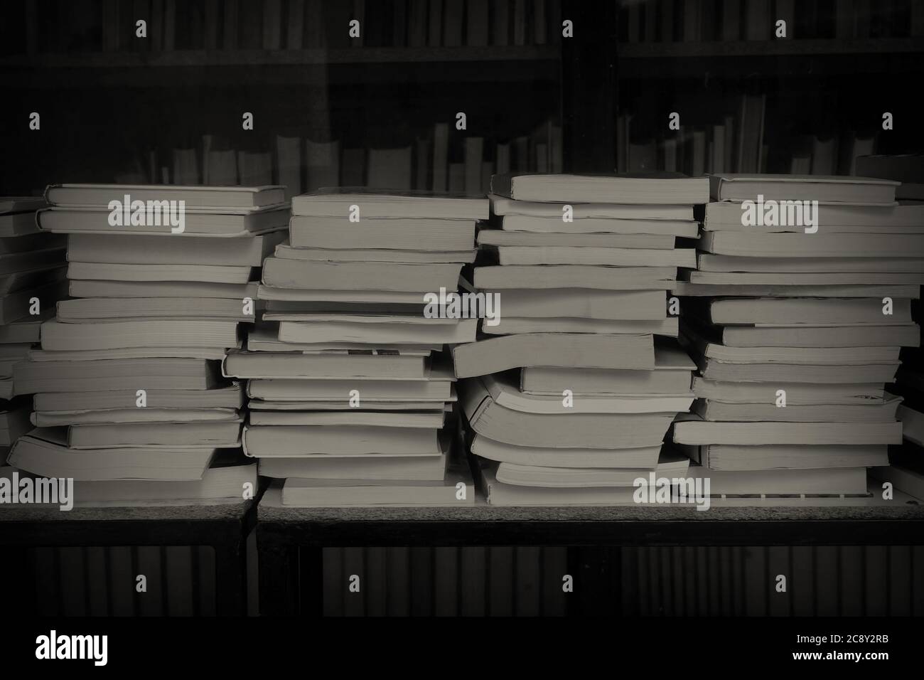 Stapel von alten gebrauchten Büchern zum Verkauf im Antiquariat. Schwarze und weiße Sepia. Stockfoto