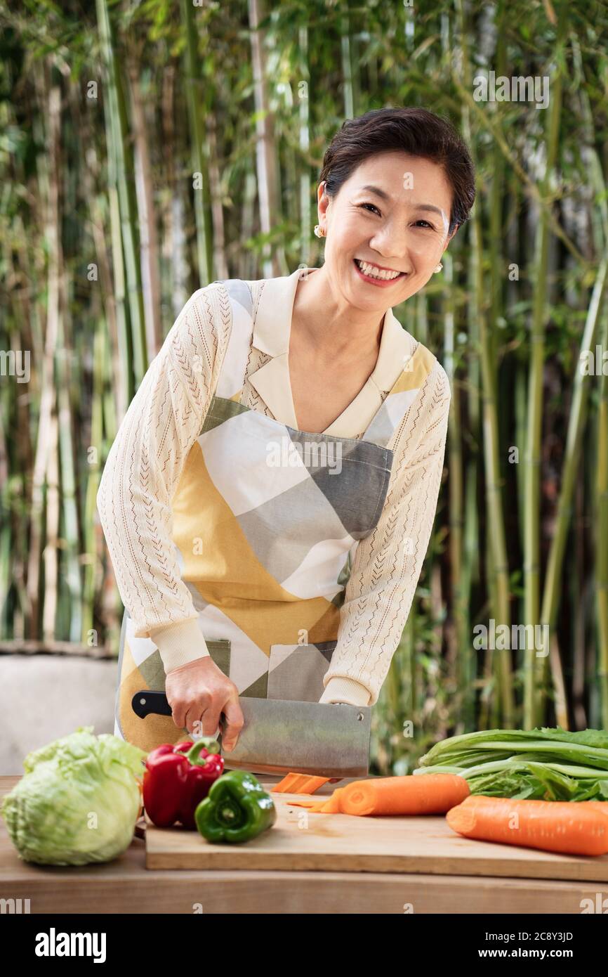 Der Hof hackt Gemüse in Midlife Frauen Stockfoto