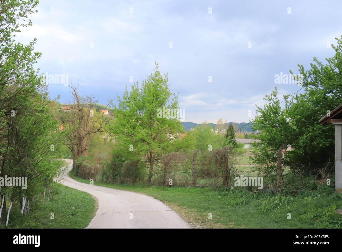 Ein dramatischer Himmel über der bosnischen Landschaft oder eine schmale Straße Stockfoto
