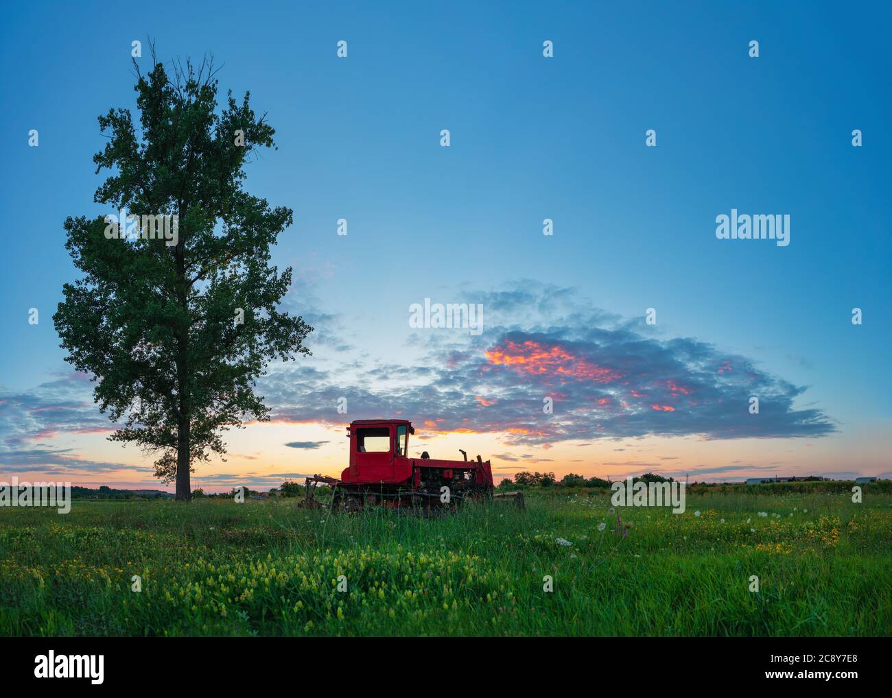 Schönen Sonnenuntergang über Feld und alten verrosteten Traktor. HDR Stockfoto