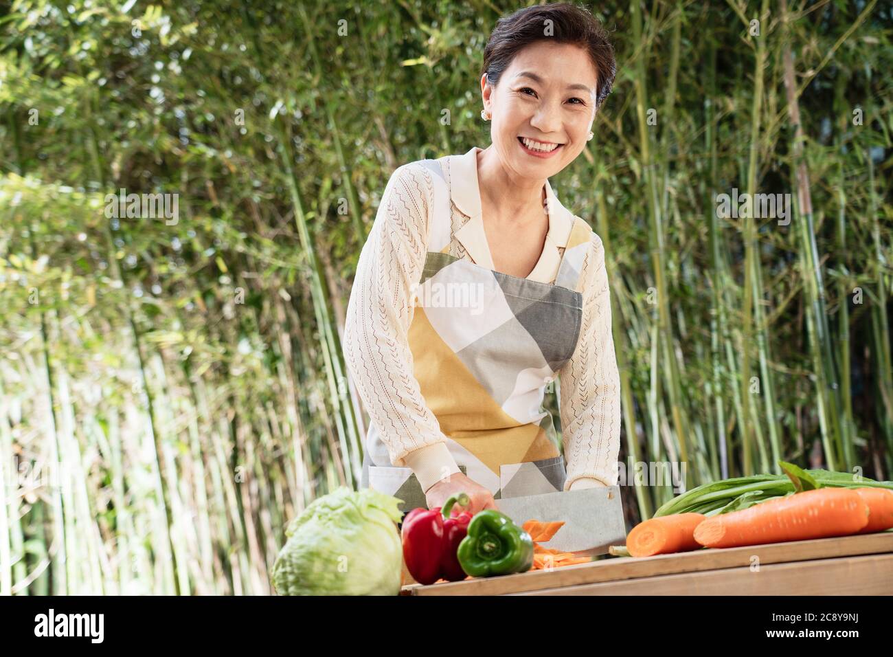 Der Hof hackt Gemüse in Midlife Frauen Stockfoto