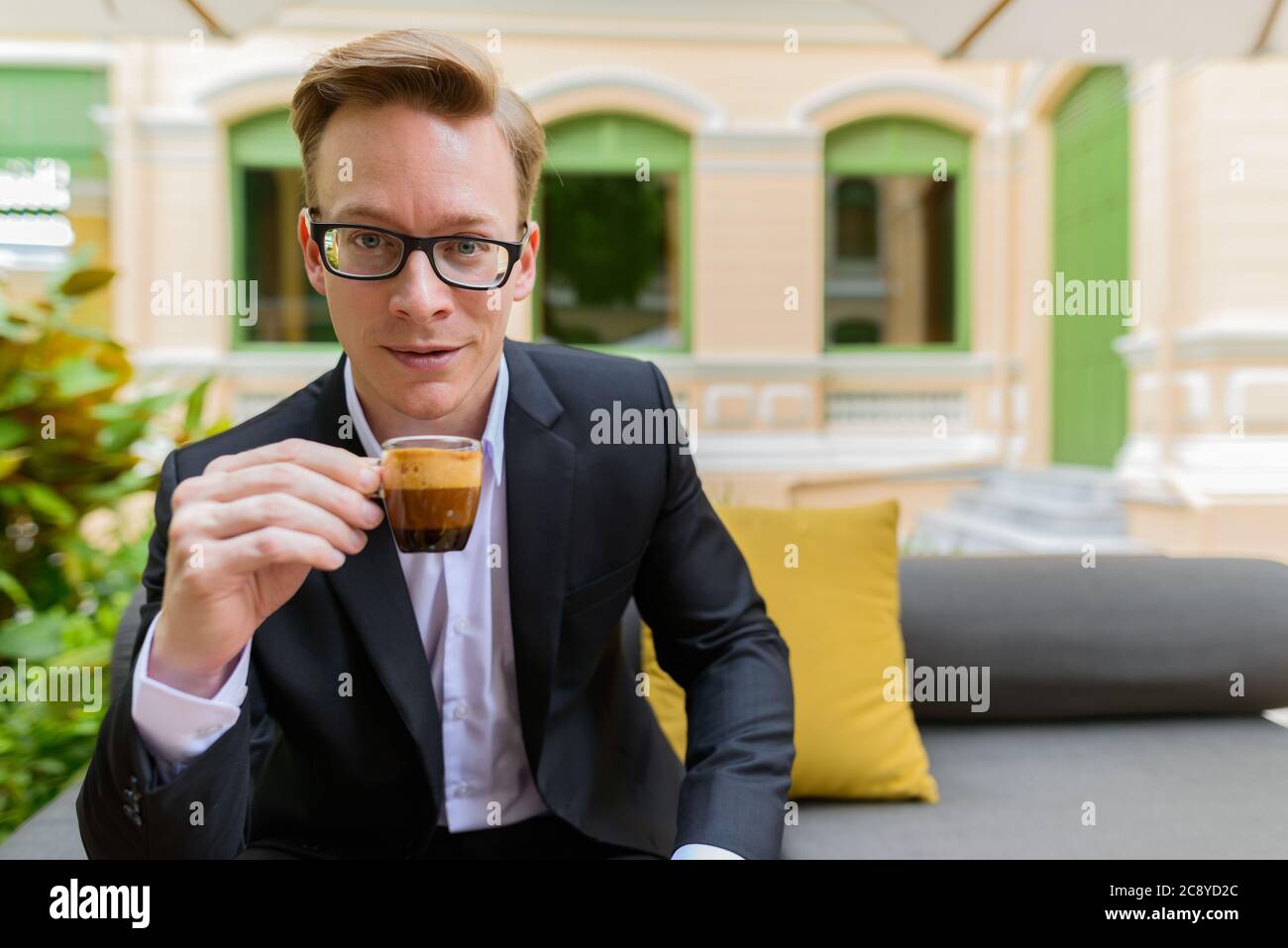 Junge schöne blonde Geschäftsmann trinken Kaffee im Café Stockfoto