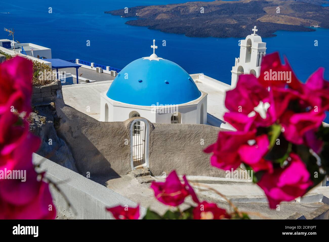 Kirche der Insel Santorini am Strand von blühenden Bougainvillea umgeben Stockfoto