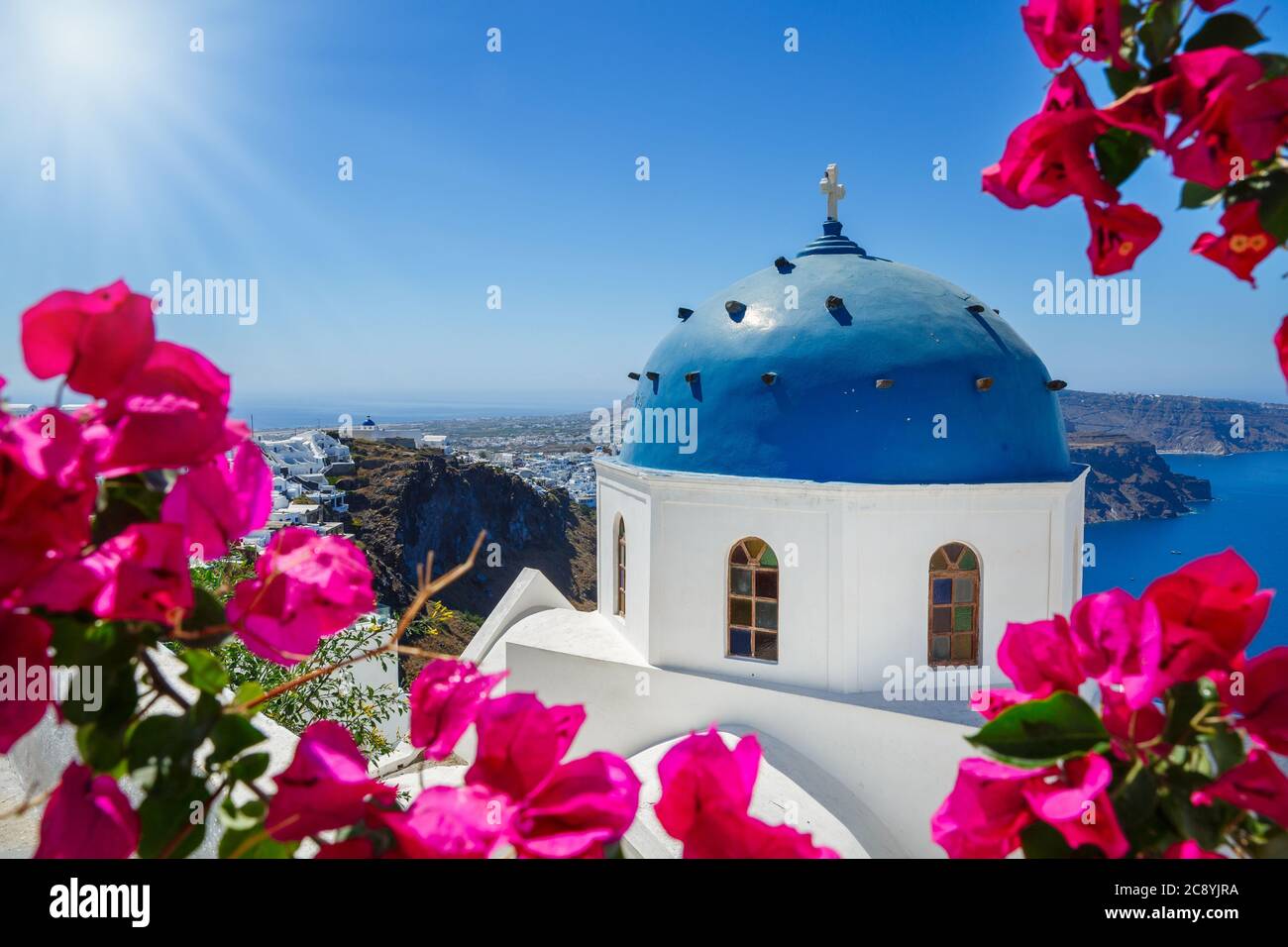 Kirche der Insel Santorini am Strand von blühenden Bougainvillea umgeben Stockfoto