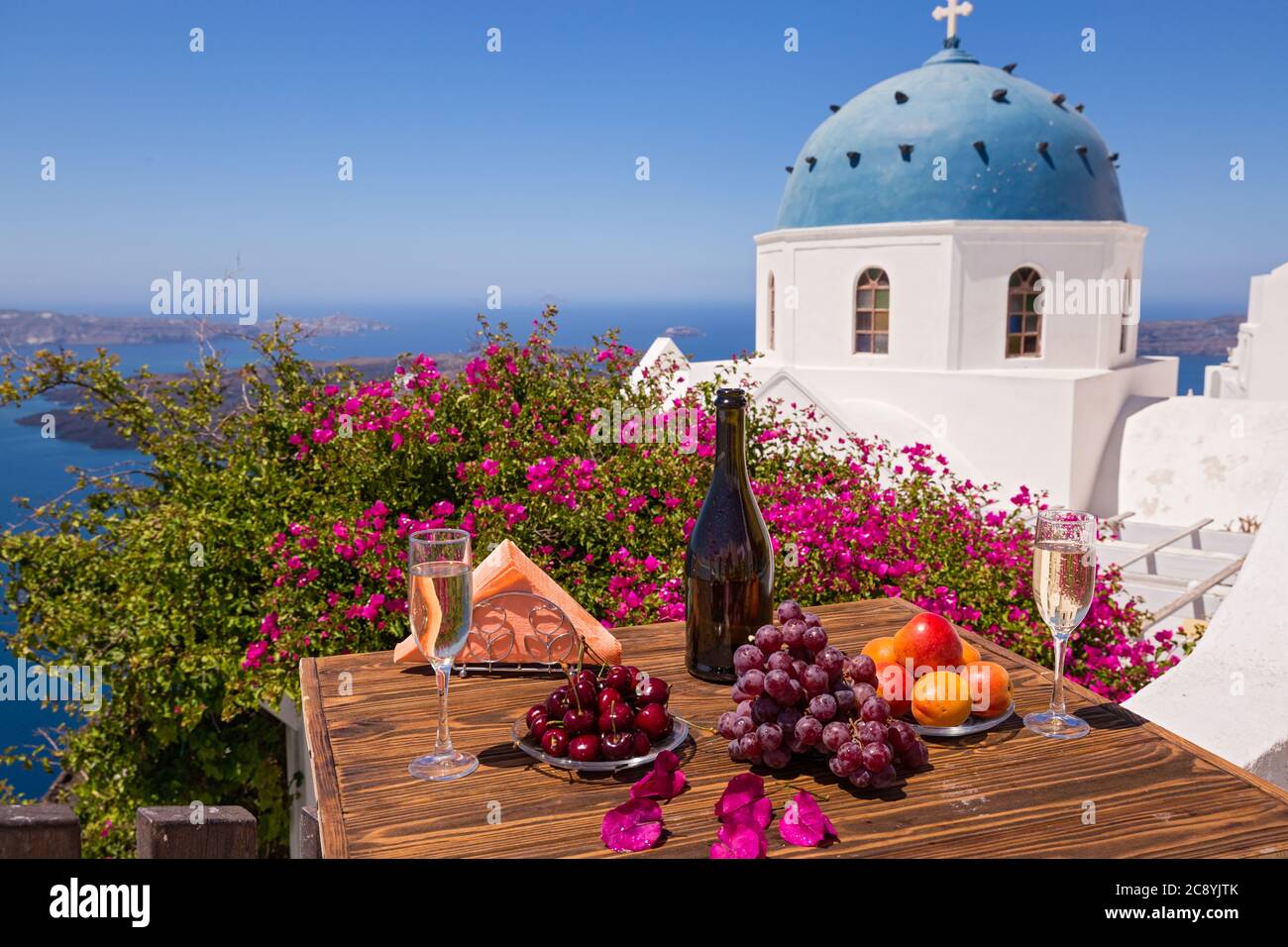 Wein und Obst für zwei auf dem Tisch vor dem Hintergrund des Meeres von Santorini Stockfoto
