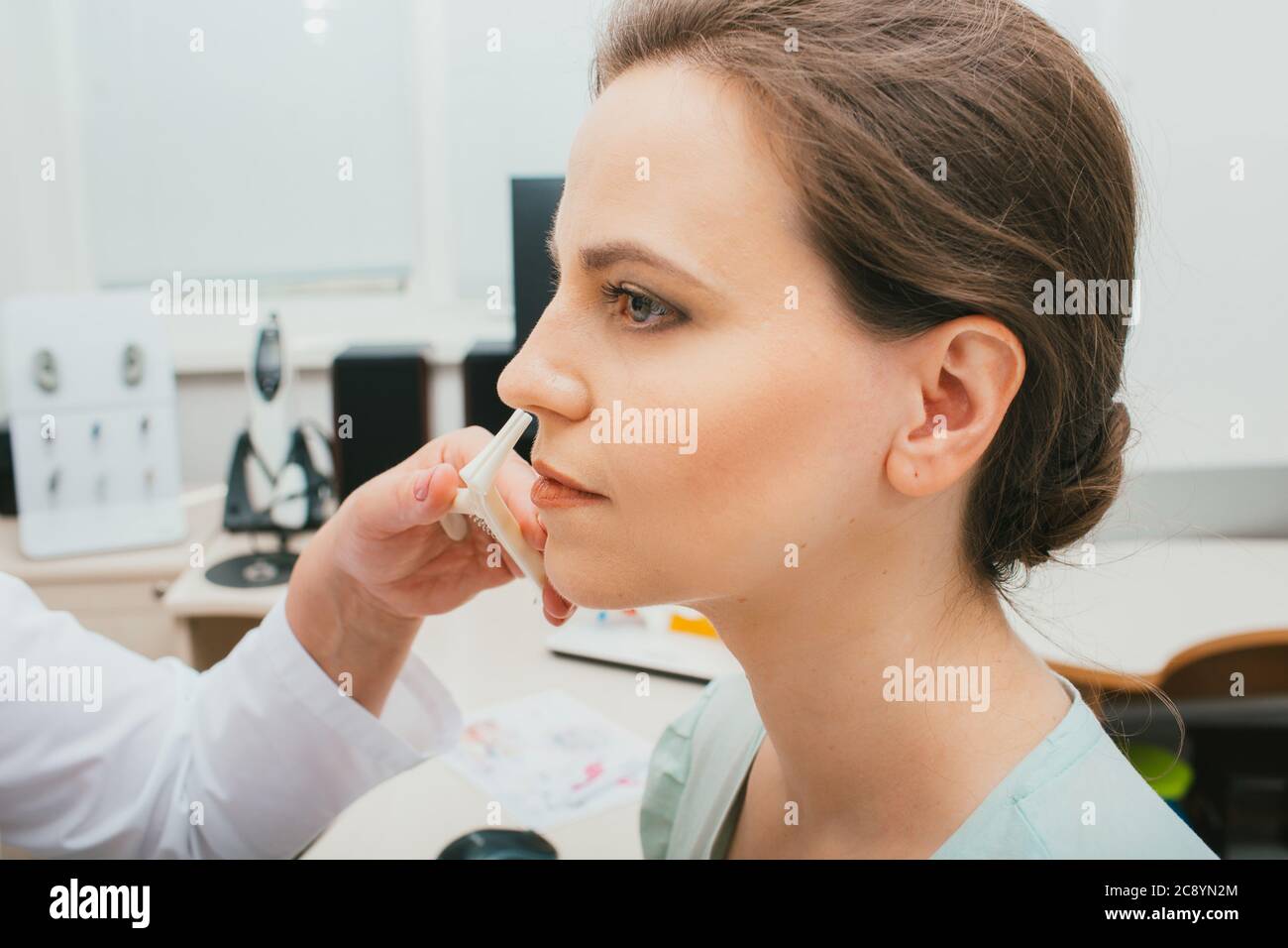 Weibliche Patientin während der Nasenkontrolle, Diagnose und Behandlung von Nasenerkrankungen. Sinusitis Behandlung Stockfoto