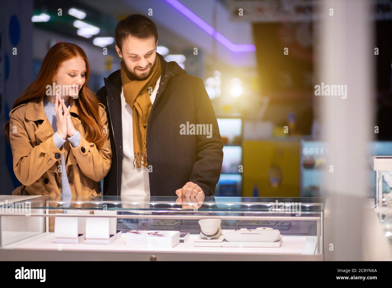 Liebe Konzept. Schöne schöne niedliche junge kaukasische Paar zusammen im Juweliergeschäft, wollen goldenen Ring kaufen Stockfoto