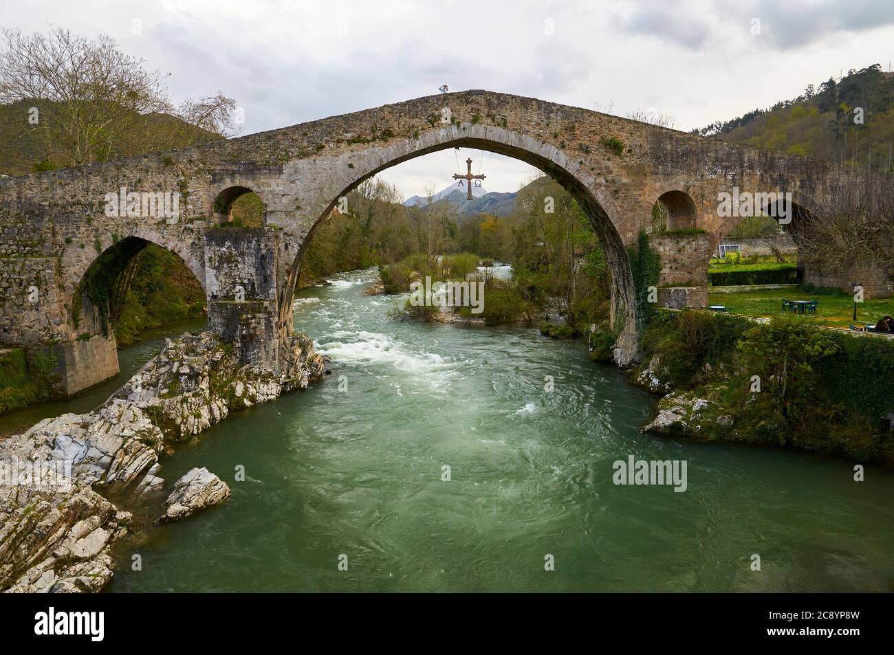 Die römische Brücke mit dem Kreuz Cruz de la Victoria, Symbol von Asturien, die über dem Fluss Sella (Cangas de Onís, Asturien, Spanien) hängt Stockfoto