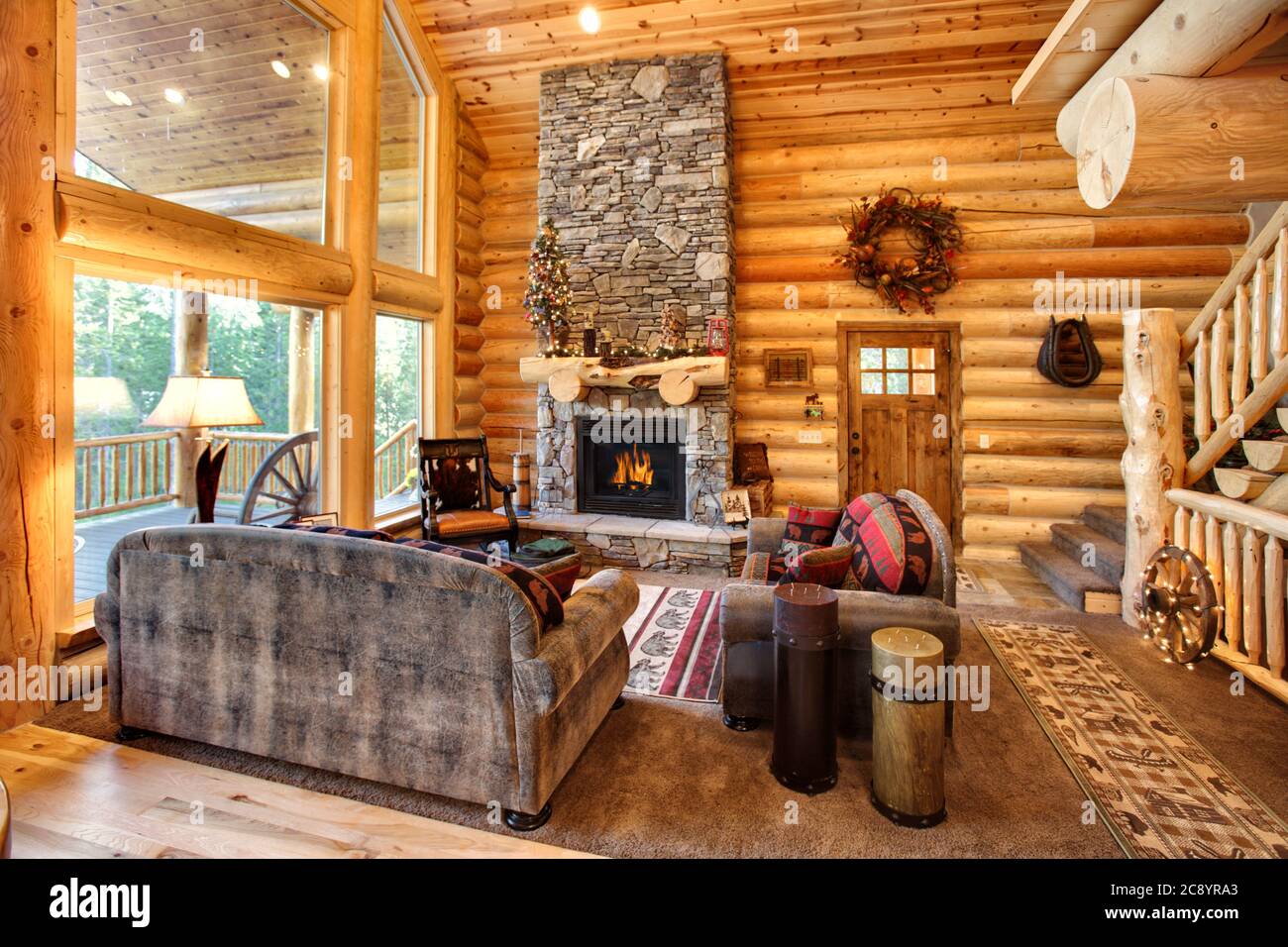 Ein luxuriöses Wohnzimmer, mit Kamin und komfortabler Einrichtung, in einer modernen Blockhütte in den Bergen. Stockfoto