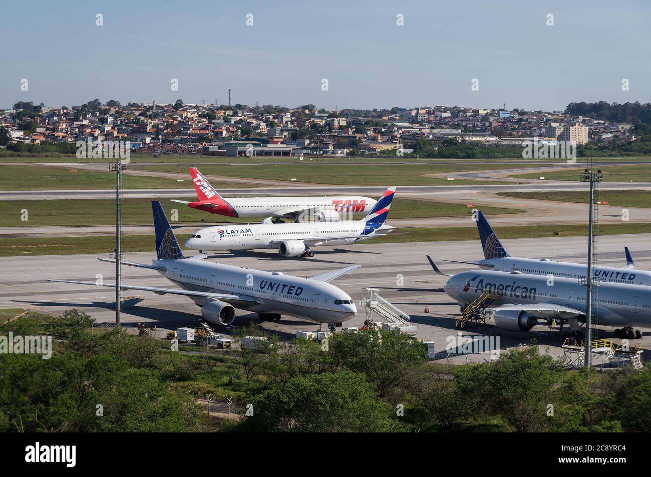 Blick von Morrinho auf die Position des Bodenverkehrs von Guarulhos Intl. Während zwei Flugzeuge direkt vor dem abgelegenen Flugzeugbereich besteuern. Stockfoto