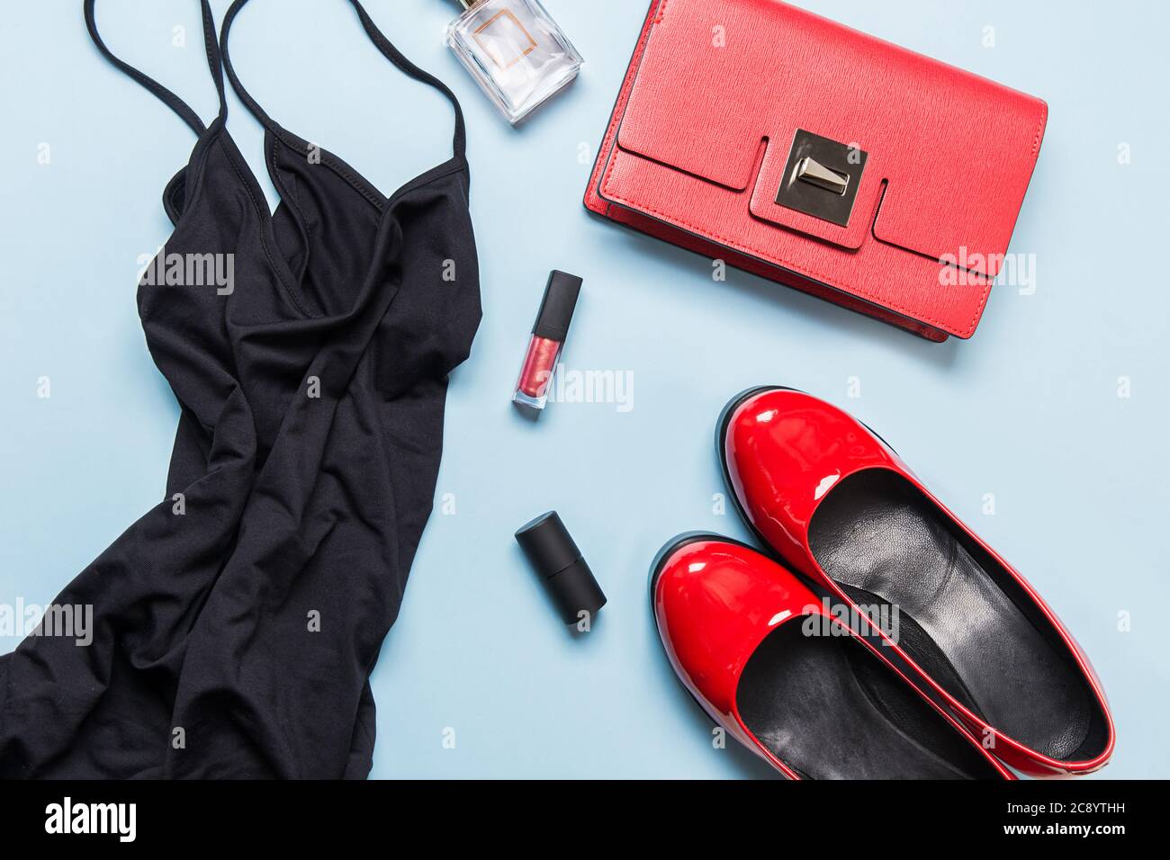 Elegantes kleines schwarzes Kleid und klassische rote Accessoires für besondere Dates. Flach liegend. Blick von oben. Vorbereitungen für die Party Stockfoto