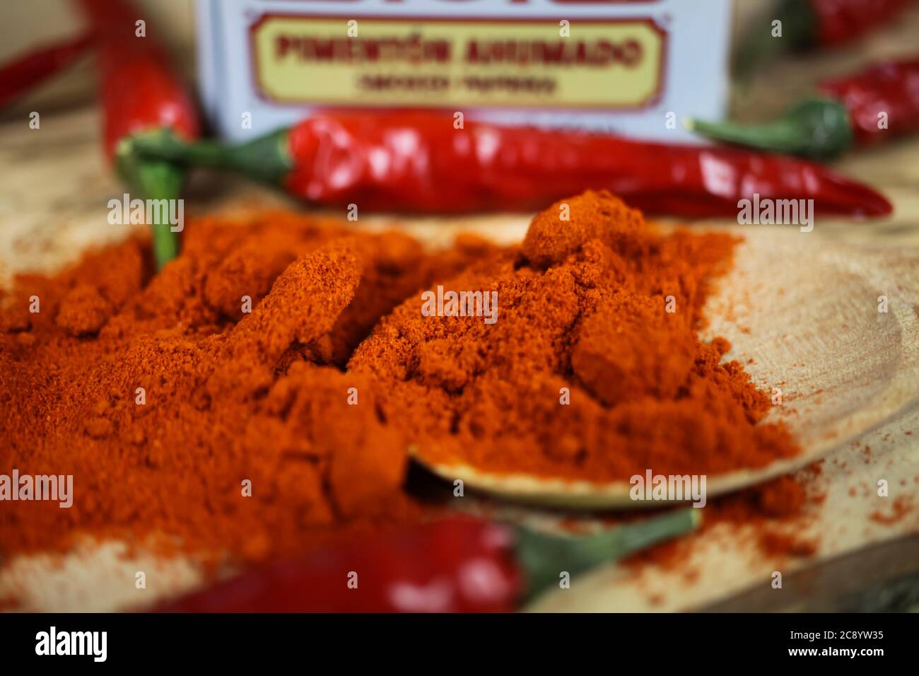 Viersen, Deutschland - 9. Juli. 2020: Nahaufnahme von über Pile rot geräuchertem Paprikapulver Gewürzen und Chilis auf Gewürzkistel Stockfoto