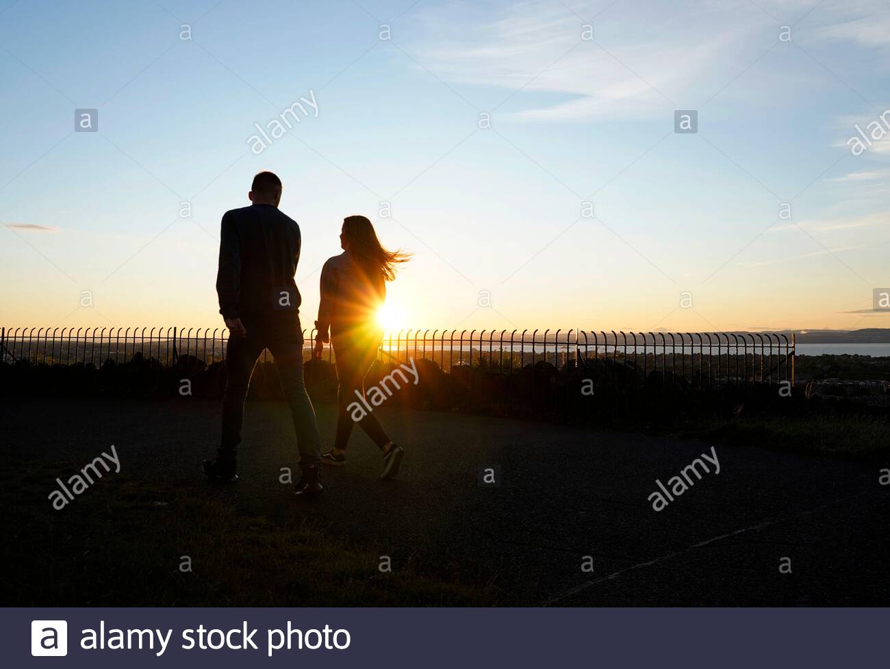 Die Menschen haben sich gegen die untergehende Sonne geschildet Stockfoto