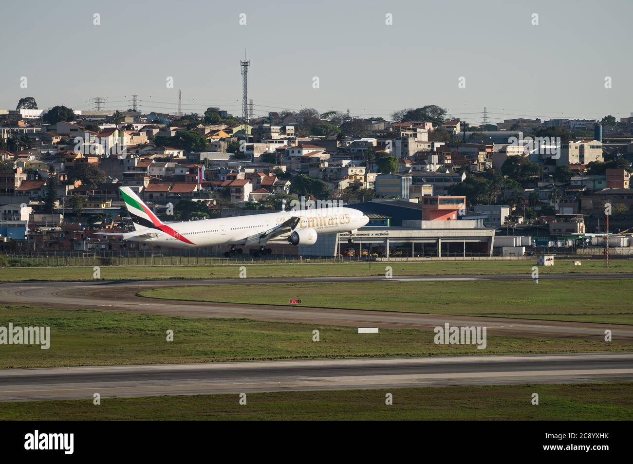 Emirates Boeing 777-31HER (Großraumflugzeug - Reg. A6-ECU) kurz vor der Berührung der Landebahn 27L von Sao Paulo / Guarulhos Intl. Flughafen. Stockfoto