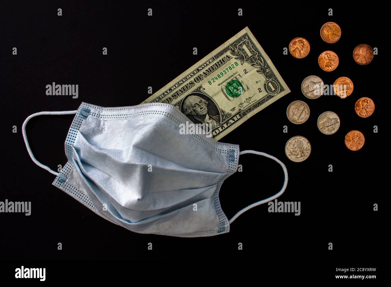Calgary, Alberta, Kanada. Juli 26, 2020. Eine Gesichtsmaske mit US-amerikanischen Scheine und Münzen. Stockfoto