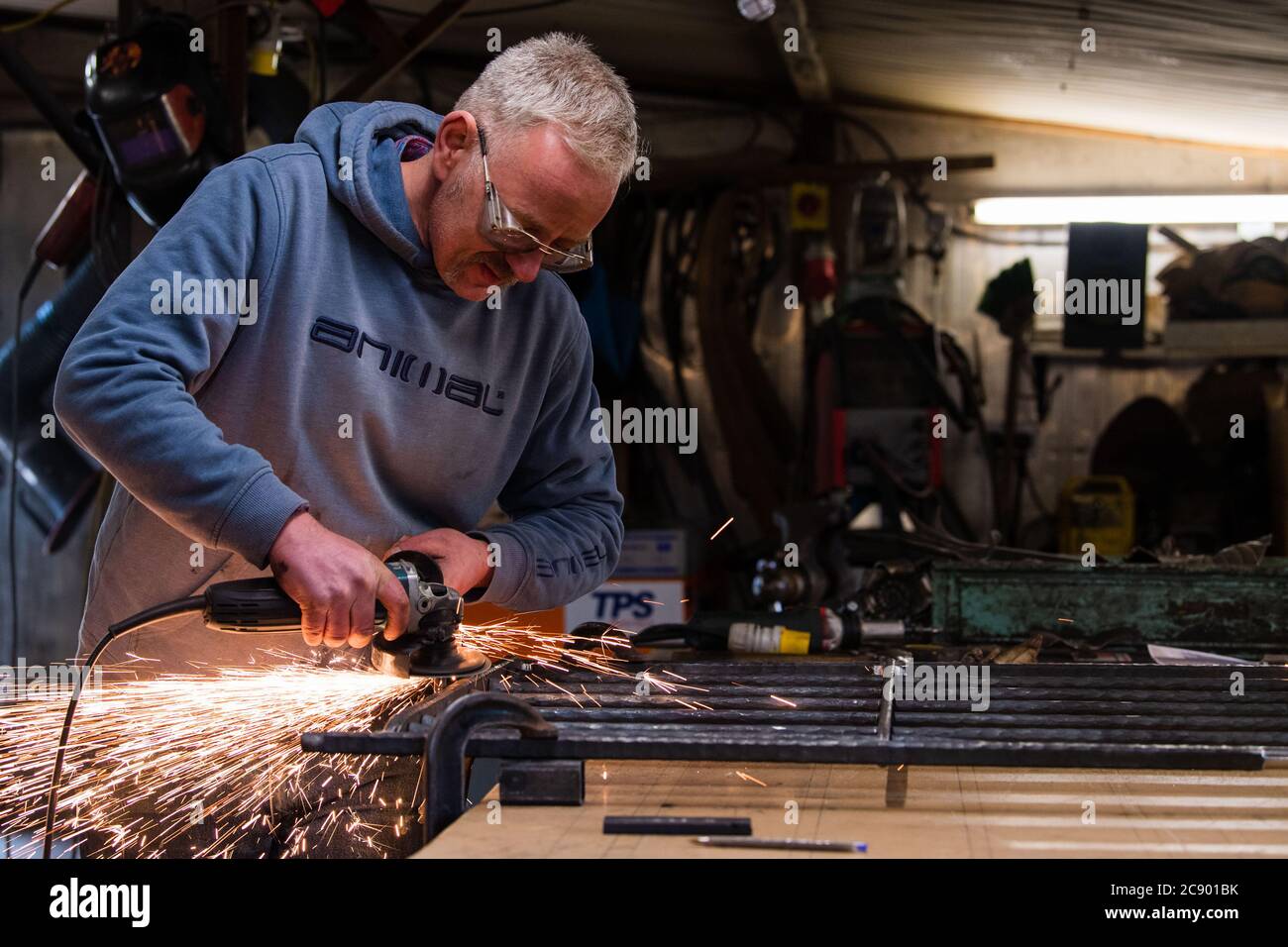 Der Blazing Blacksmith Jim Whitson arbeitet an einem Gartentor In seiner Werkstatt bei Waterheads bei Eddleston Stockfoto