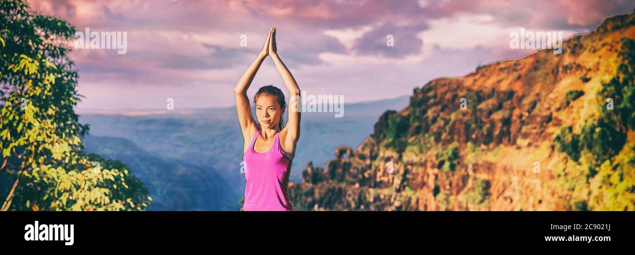 Yoga Retreat in Kauai Natur Panorama Banner. Asiatische Mädchen üben Meditation im Freien in Sonnenuntergang sitzen mit betenden Händen über dem Kopf für Baum Pose Stockfoto