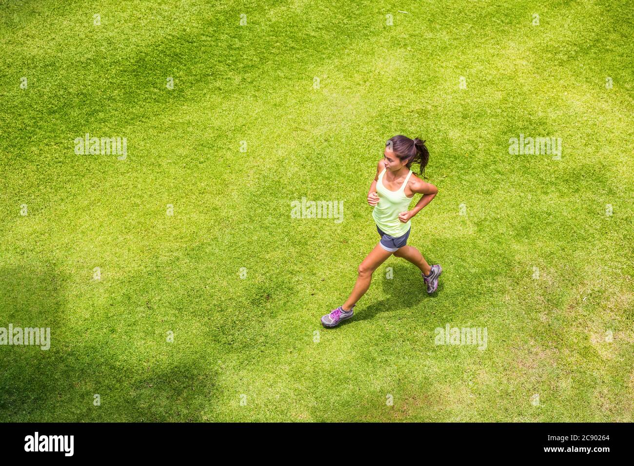 Aktive Sport Frau Läuferin läuft auf Gras im Freien Training für Marathon. Asiatische chinesische sportliche Mädchen am Morgen laufen Stockfoto