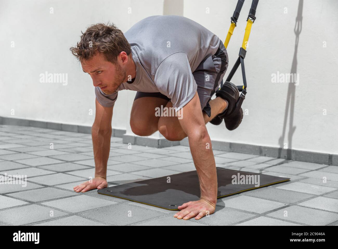 Mann trainiert abs-Kernkörpermuskeln mit Federung Fitness-Gurte im Fitnessstudio. Magen Bauchmuskeln Training gesunde Lebensweise Sport Stockfoto